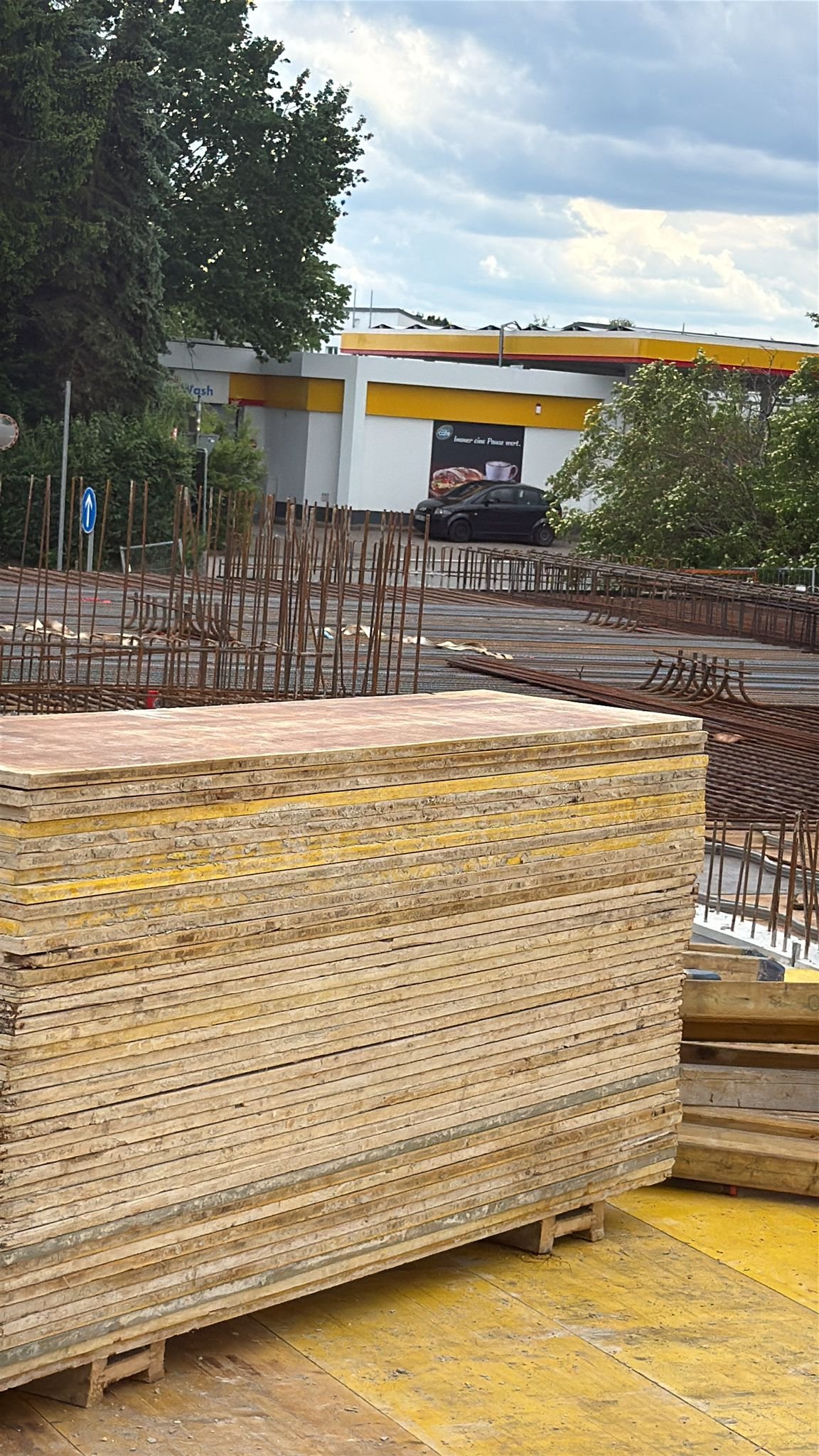 Gestapelte Schalungstafeln und Bewehrungsstahl auf der Baustelle