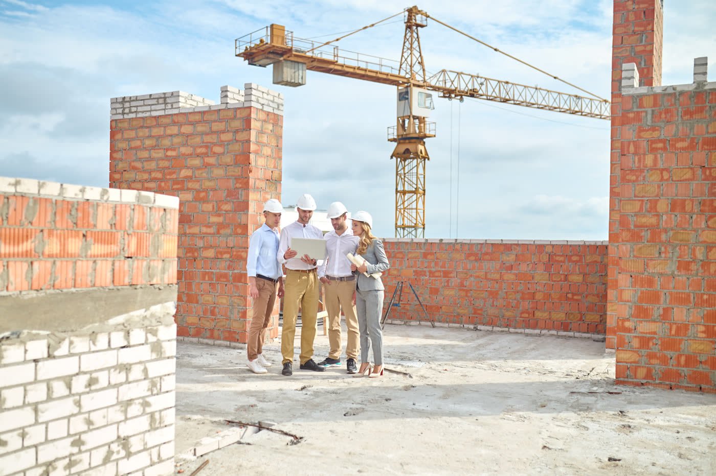 Bauleitung bespricht Pläne auf einer Rohbau-Baustelle